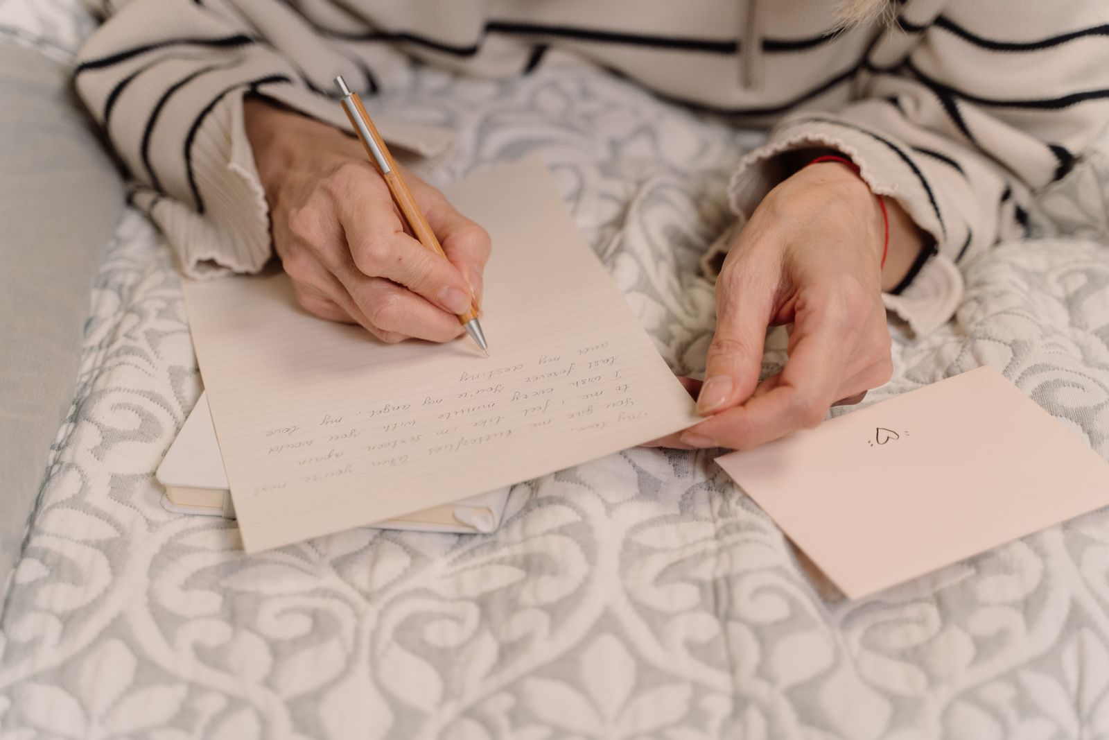 Käsi kirjoittaa henkilökohtaista kirjettä paperille